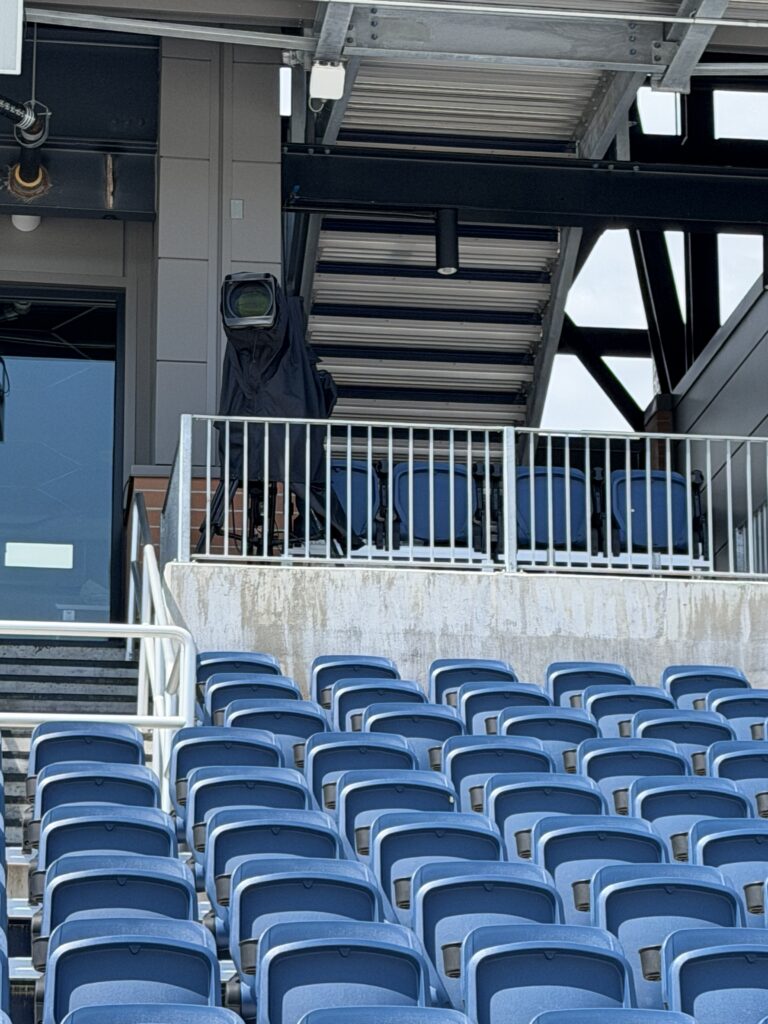 Protected camera position in the stadium seating for Bill Burr at Centreville Bank Stadium.